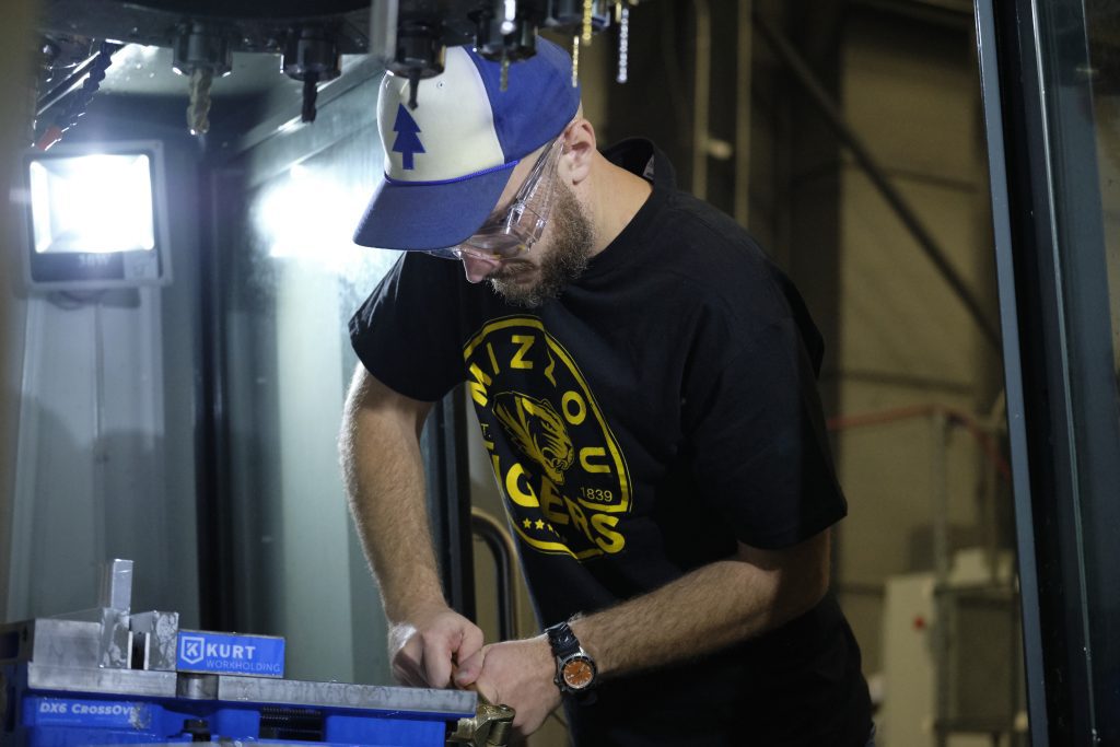 A University of Missouri student works inside a CNC machine.