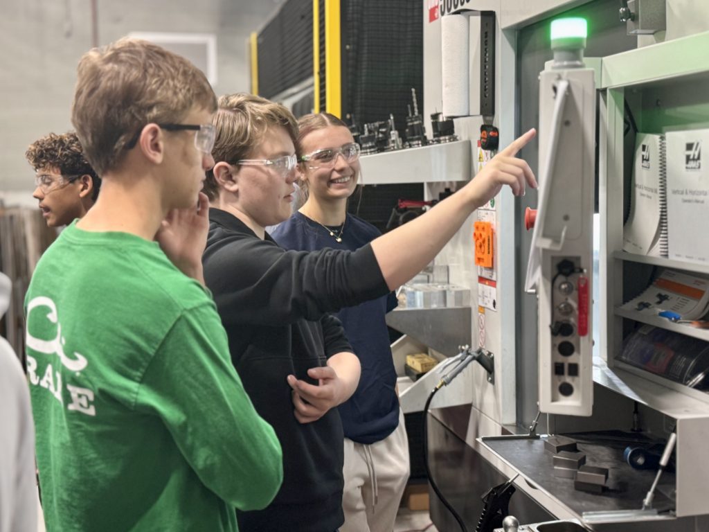 Students work on a CNC machine.